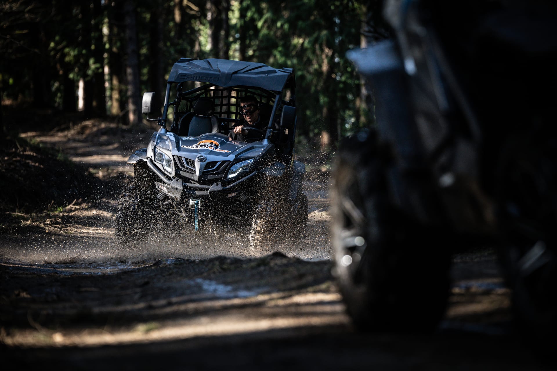 Buggy a atravessar uma poça num caminho florestal