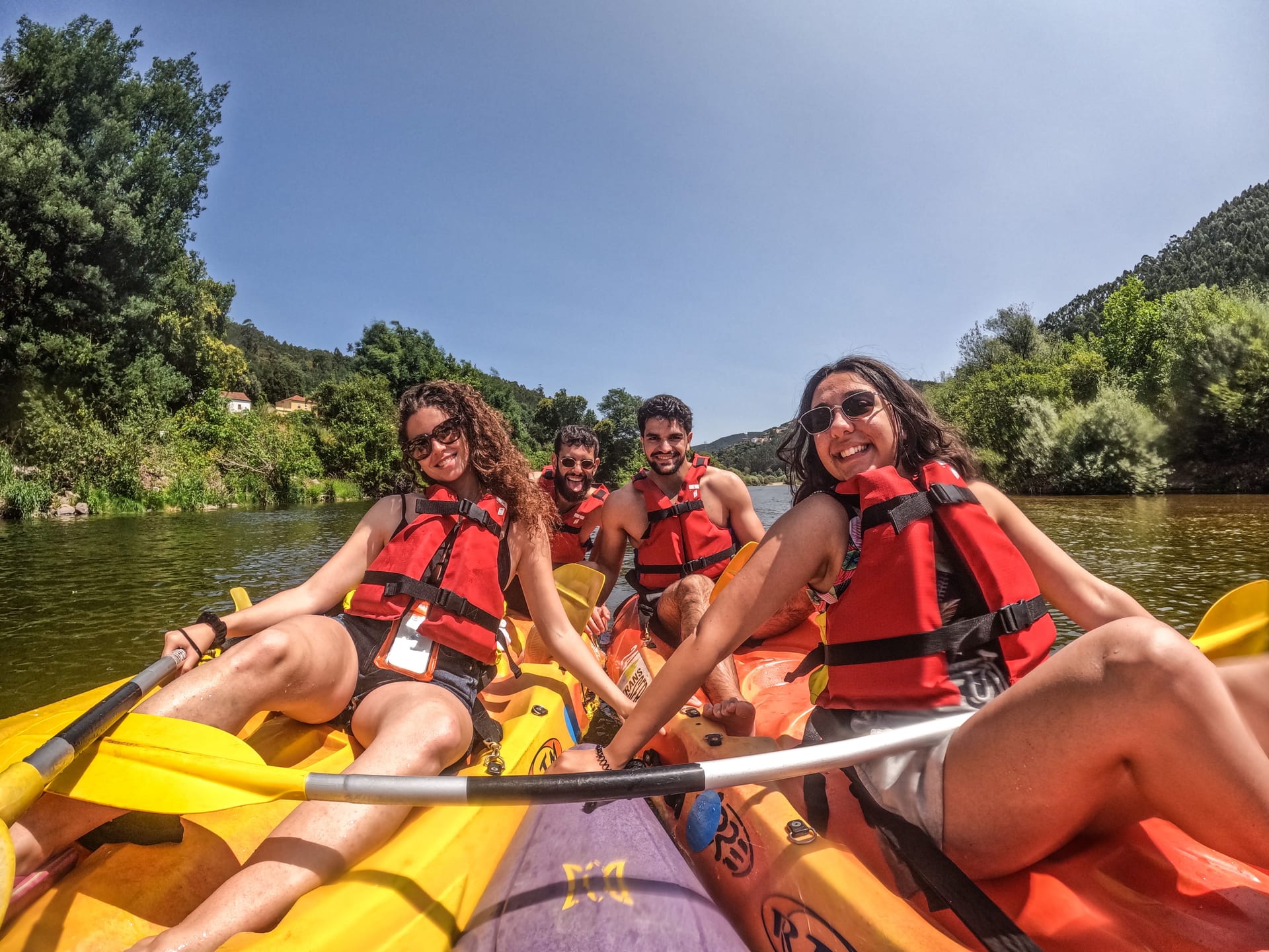 Grupo de amigos a remar em conjunto num rio