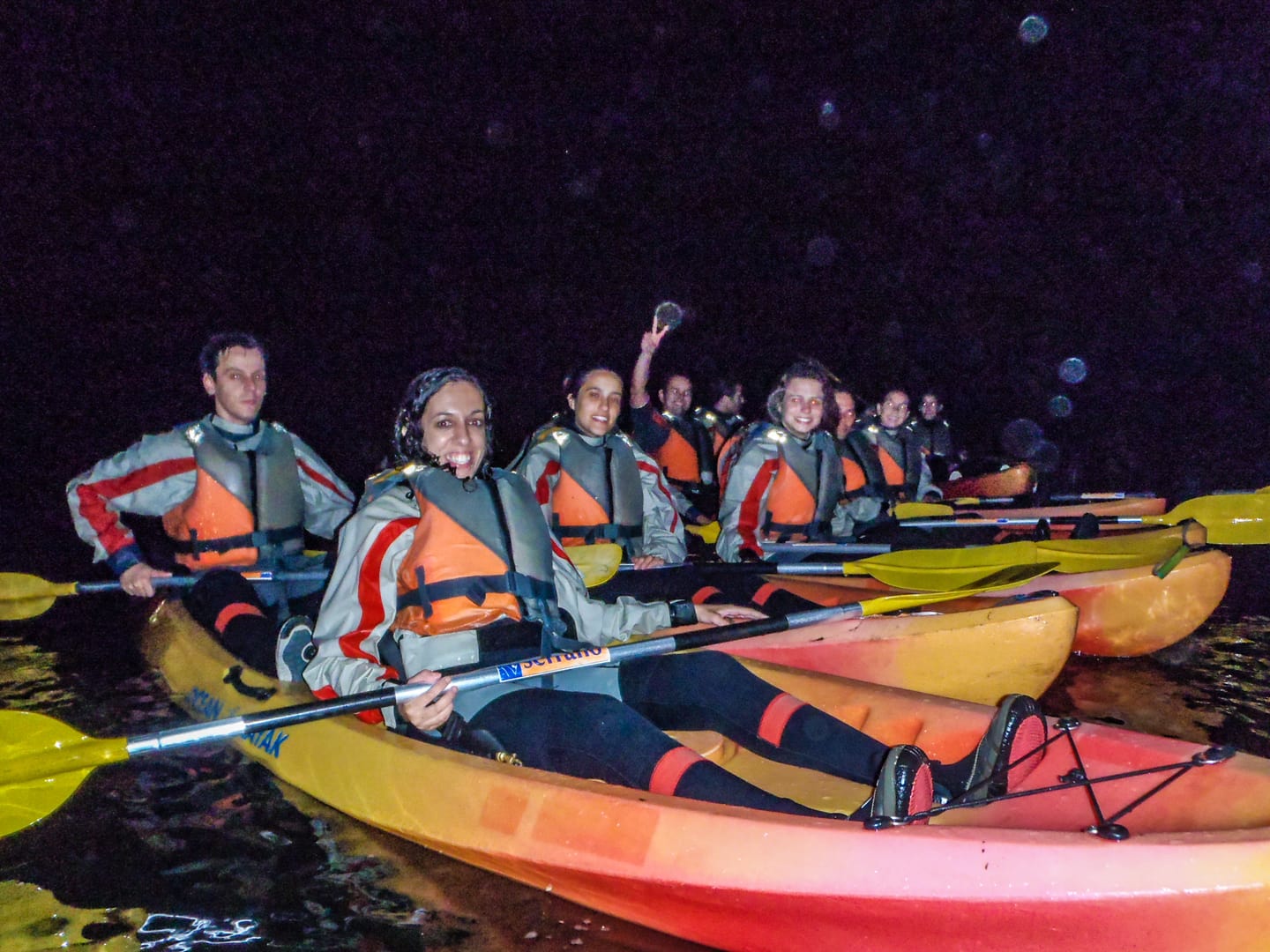 Group in canoes wearing buoyancy aids during a night outing.