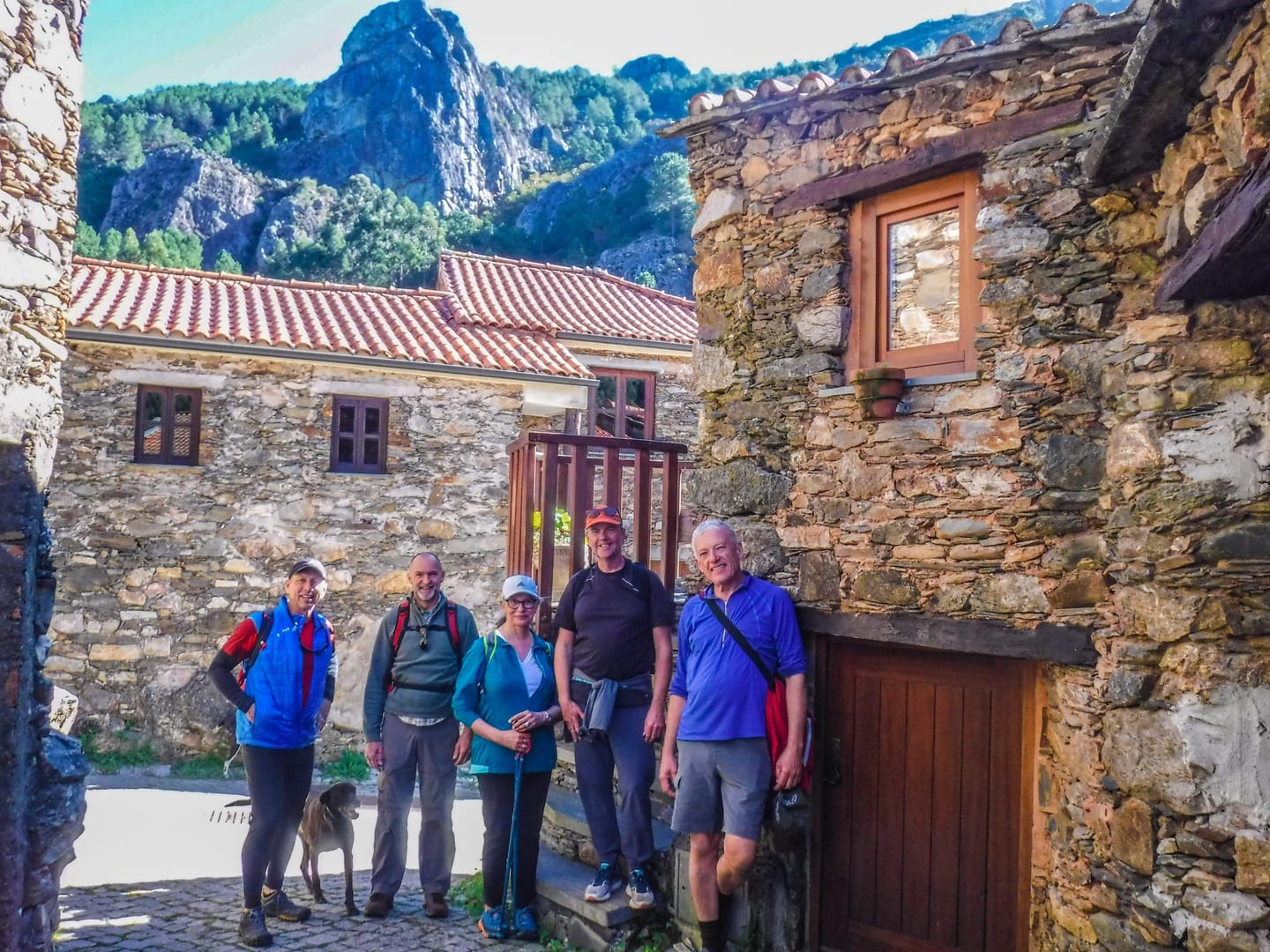 Walkers beside schist houses below Penedos de Góis