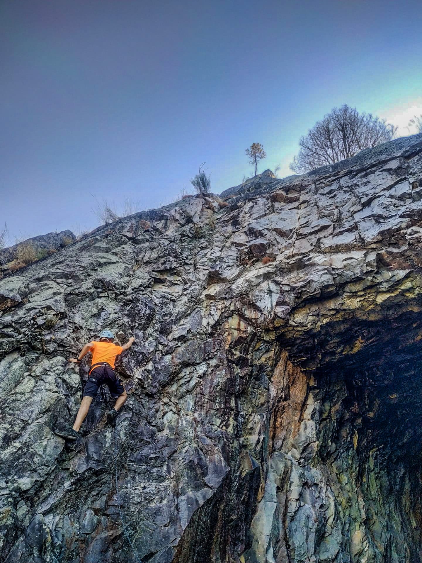 Equipped participant climbing a rock face