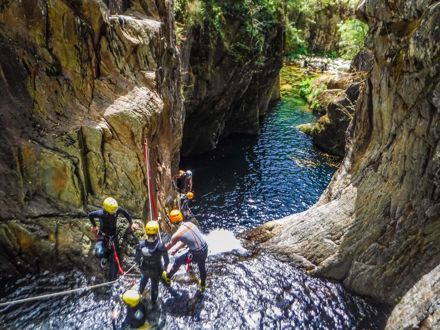 Participantes equipados junto a uma lagoa entre escarpas do Teixeira
