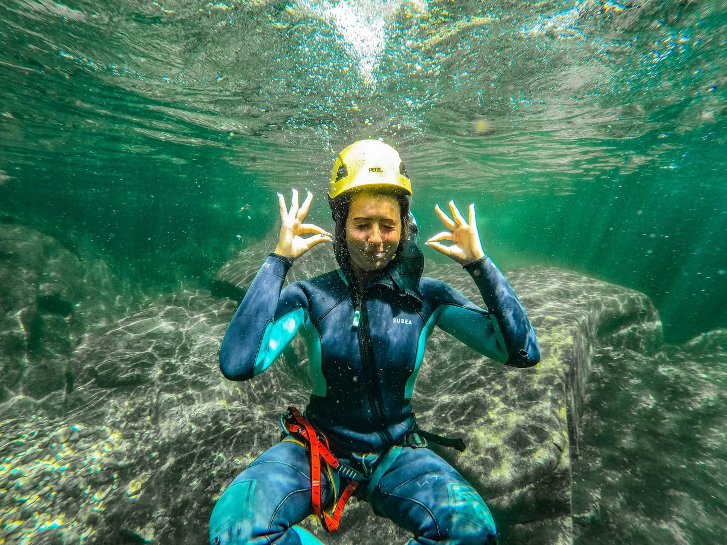 Participante com capacete a nadar numa lagoa do Vessadas
