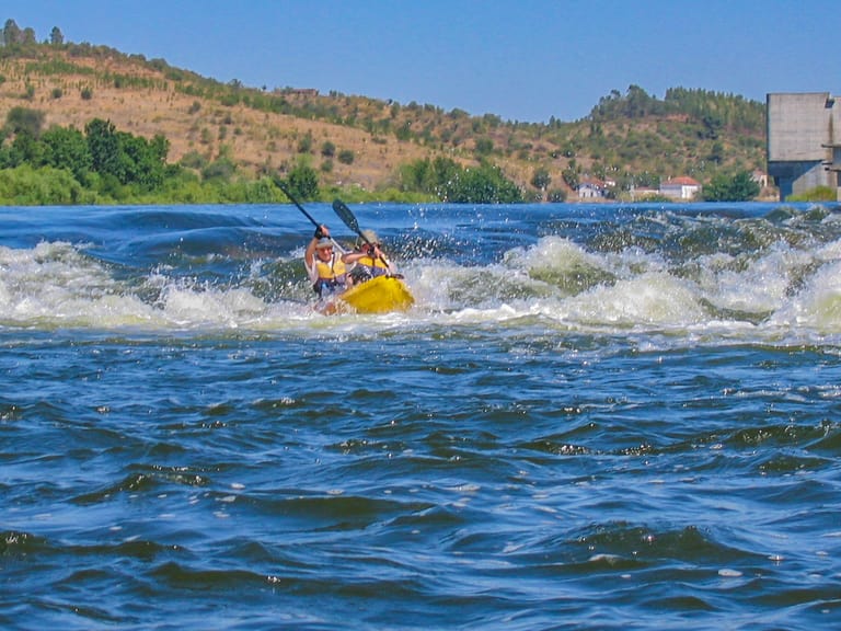 Canoísta equipado a atravessar uma passagem de água no Tejo