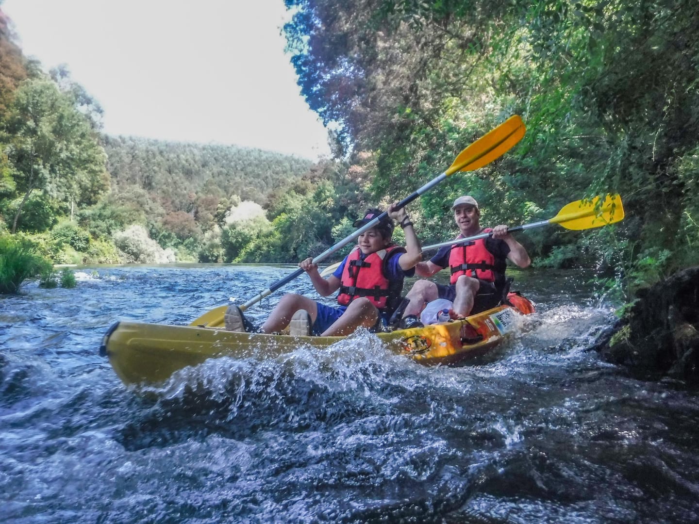 Team in a yellow canoe crossing a Vouga rapid